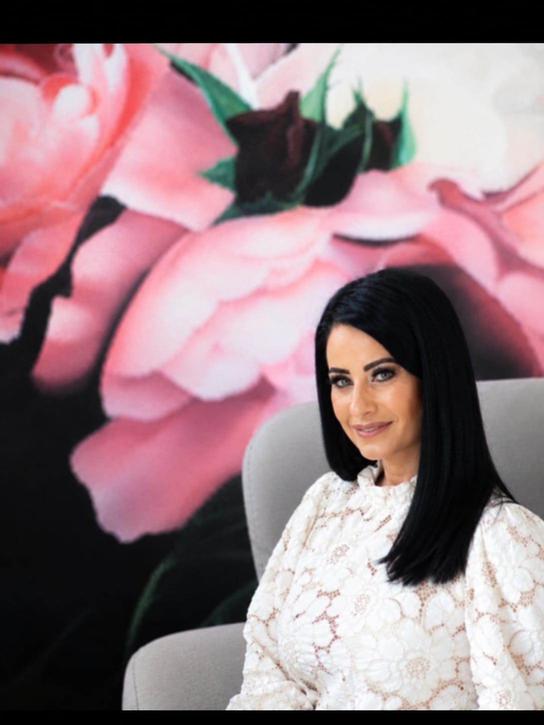 Portrait at Face & Body Studio SA against the pink floral wall